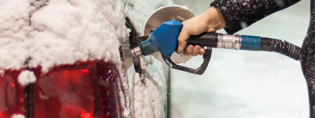 person pumping gas in winter