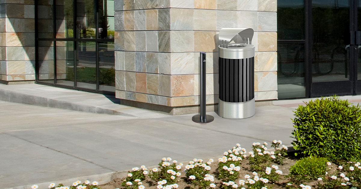 16979_2026CZBlogLinkedInArticles_Mar_LinkedInHeader_1c Smoker’s Outpost® Smoke Stand, Parkview Black and Stainless Steel Trash Container, 25-Gallon Round, Canopy Lid outside of an apartment building